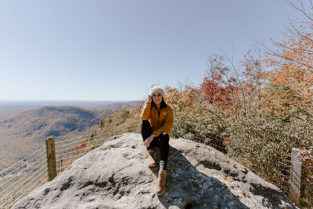 Woman sitting on a rock at Whiteside Mountain in Highlands, NC