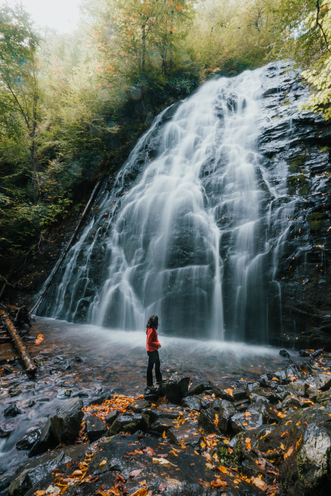Woman admiring large, cascading waterfall 
