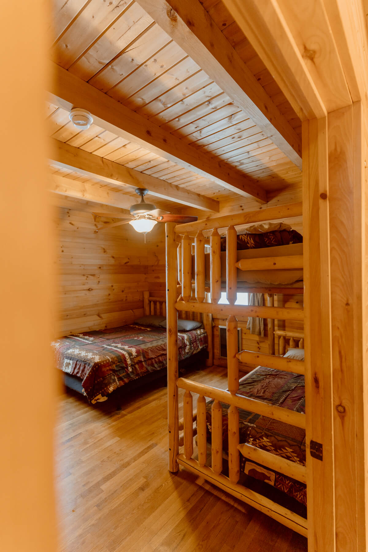 Bedroom with a bed and a bunk bed inside a log cabin