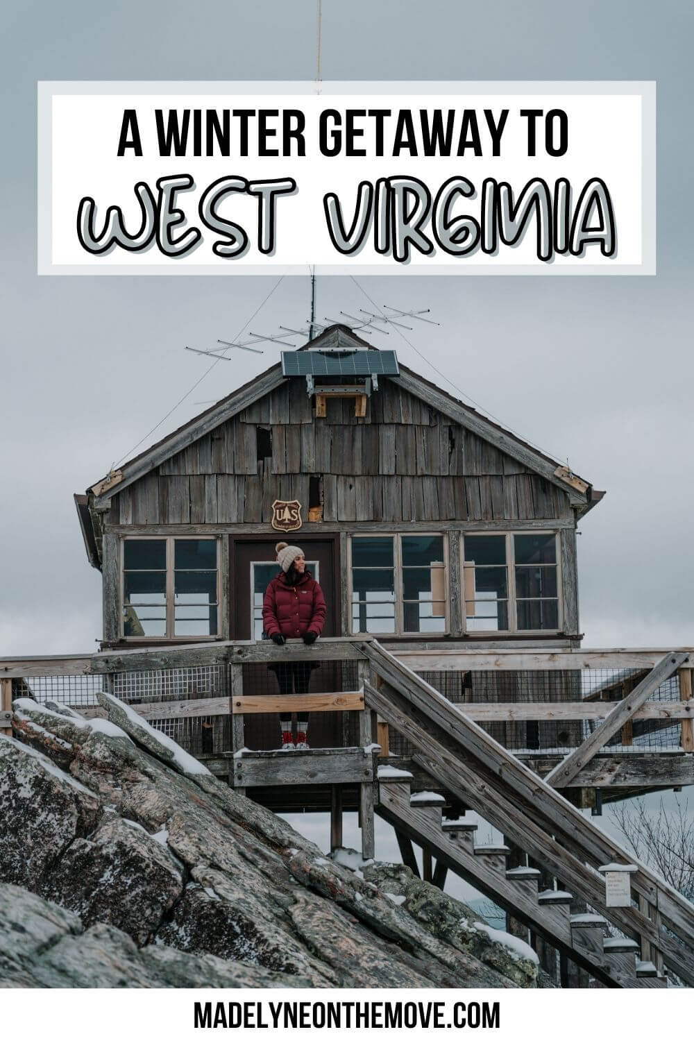 Woman standing in front of lookout tower on a snowy day