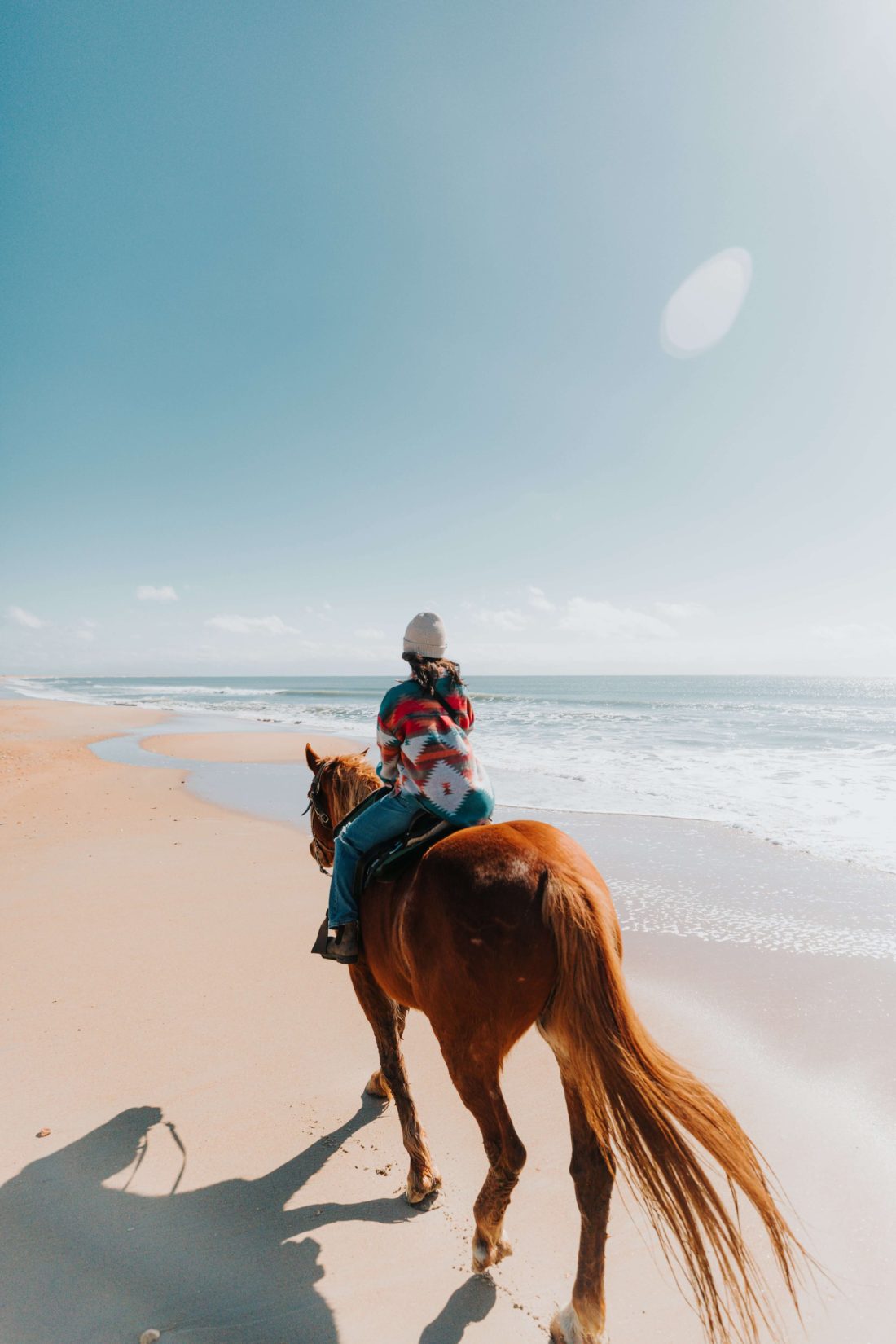 Woman riding a chestnut horse on Cape Hatteras National Seashore