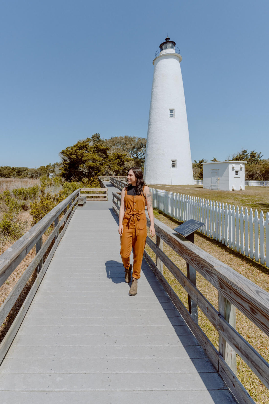 Woman standing on the boardwalk in front of Ocracoke Lighthouse