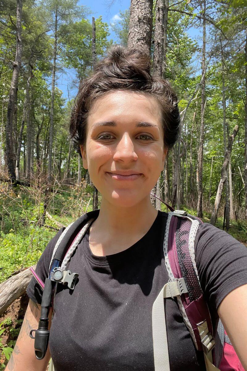 Selfie of a brunette woman hiking through the woods